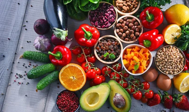 Table full of a rainbow of fruits and vegetables supporting healthy immune system resilience 