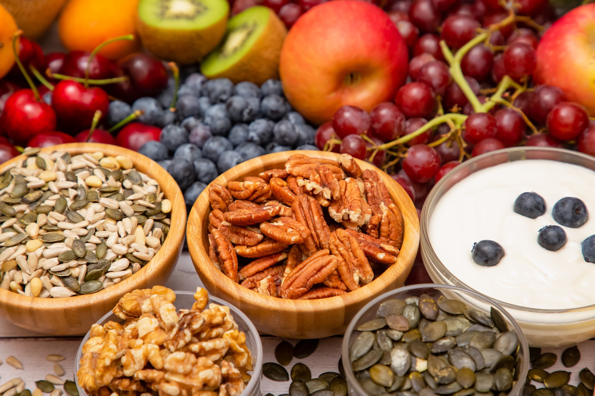 Nuts and fruit in bowls showing that nutrition can help balance thyroid hormones.