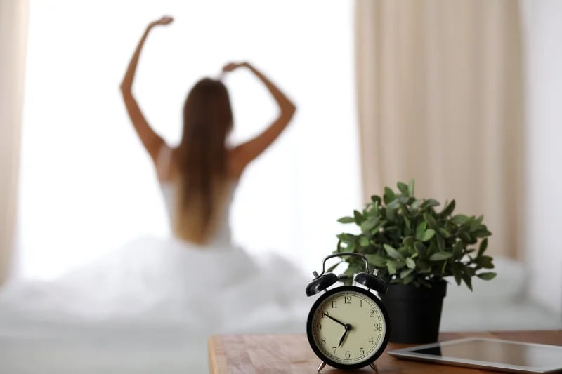 Closeup of a clock as a women dances ballet and uses functional medicine to improve her circadian rhythm in the background