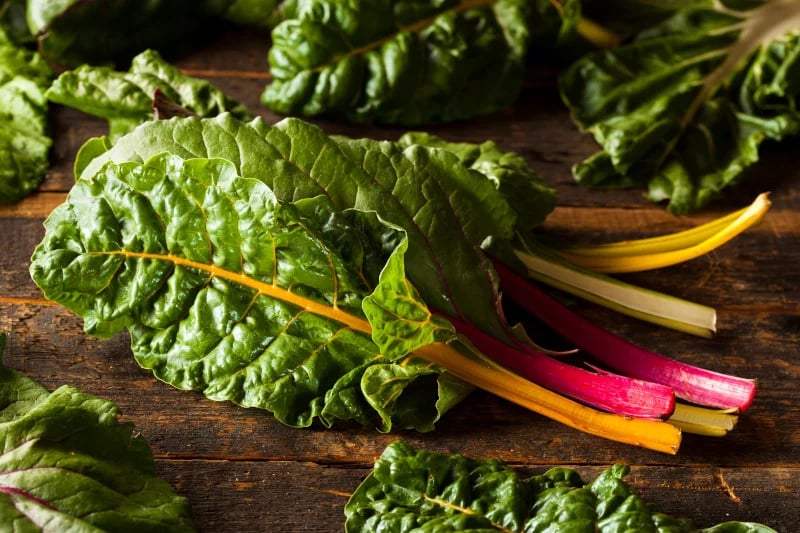 Collard greens on a wooden table are essential for supporting the liver and reducing toxins.