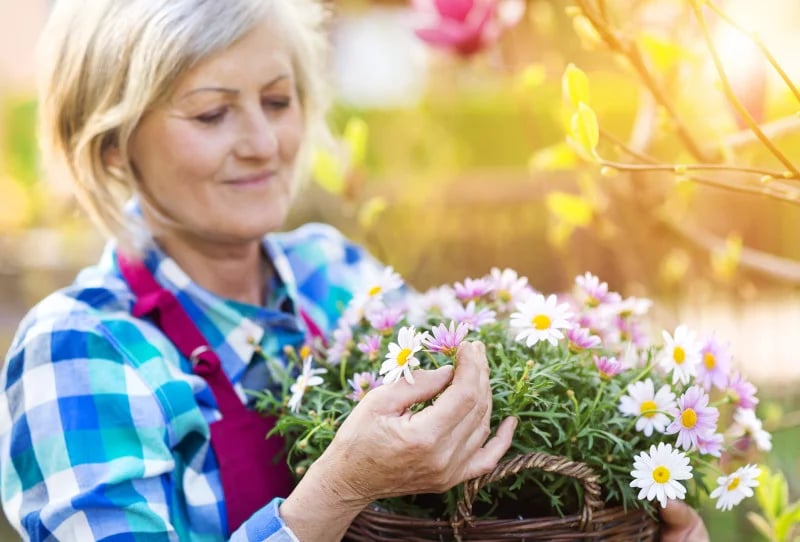 Woman holding flowers and smiling because functional medicine has helped her reproductive health.