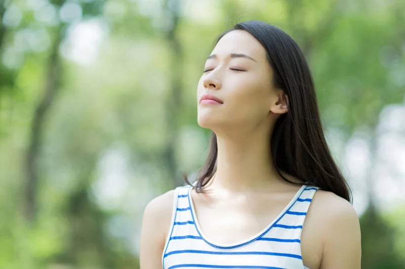 Woman in the park looking towards the sky, she's at peace knowing nutrition has helped treat her GERD.